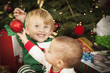 Mixed Race Baby and Young Boy Enjoying Christmas Morning Near Th