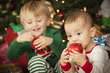 Mixed Race Baby and Young Boy Enjoying Christmas Morning Near Th