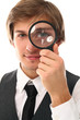 Smiling man in a suit looking through magnifier