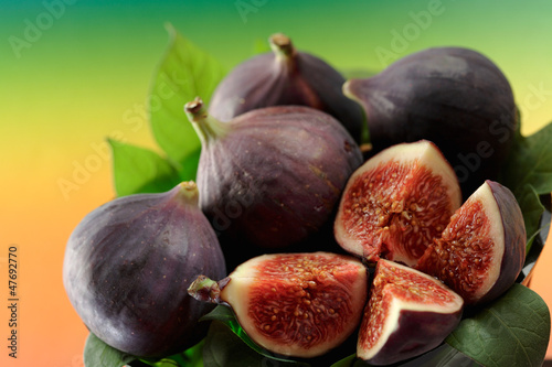 Photo: Several fresh figs with leaves, whole and cut Several fresh figs with leaves, whole and cut