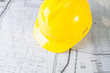 Construction plans with yellow helmet