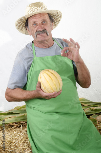 Photo: Biobauer mit einer Honigmelone in der Hand Biobauer mit einer Honigmelone in der Hand