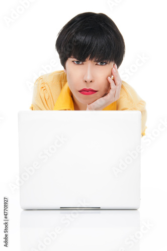 Photo: Young woman with laptop looking angry Young woman with laptop looking angry