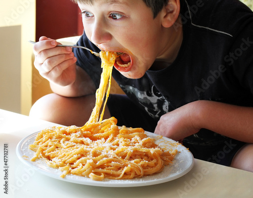 Photo: Funny boy eating spaghetti. Funny boy eating spaghetti.