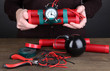 Human makes timebomb on wooden table on black background