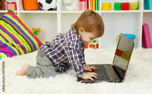Photo: cute little boy and notebook in room cute little boy and notebook in room