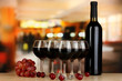 Red wine in glass and bottle on room background
