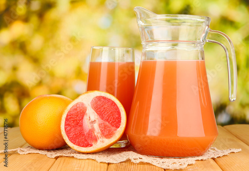 Photo: Full glass and jug of grapefruit juice and grapefruits Full glass and jug of grapefruit juice and grapefruits