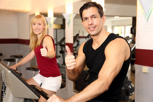 Photo: Attractive woman and a man cycling in a gym Attractive woman and a man cycling in a gym