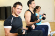 Group of three people training with gymnastic balls and dumbbell