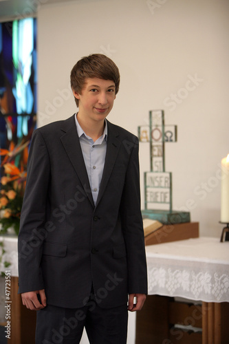 Photo: Konfirmant vor dem Altar der Kirche Konfirmant vor dem Altar der Kirche