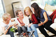 4 girls with smartphones on the sofa