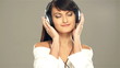 A young woman listening to the music in headphones