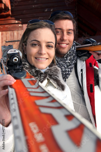 Photo: Couple of skiers stood by their chalet Couple of skiers stood by their chalet