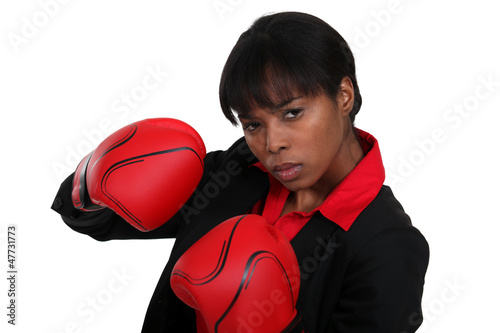 Photo: Female office worker wearing boxing gloves Female office worker wearing boxing gloves