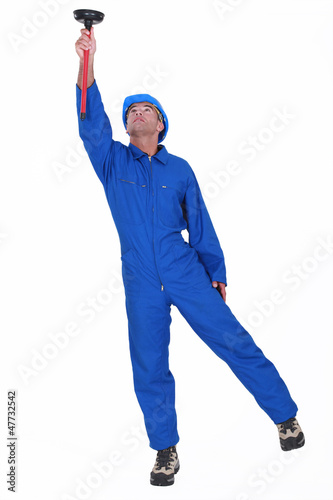 Photo: A plumber unplugging the ceiling. A plumber unplugging the ceiling.