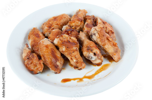 Photo: Plate with roasted chicken wings, isolated on white Plate with roasted chicken wings, isolated on white