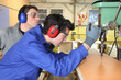 Young man learning how to use a drill press