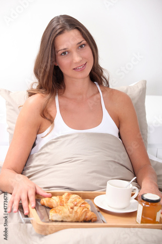 Photo: Woman eating breakfast in bed Woman eating breakfast in bed