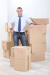 Horizontal image of a man surrounded by cardboard
