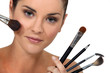 Woman posing with her make-up brushes