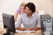 Man repairing computer for attractive blond