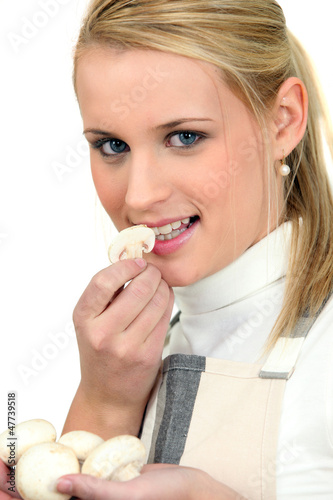 Photo: young woman smelling fresh mushrooms young woman smelling fresh mushrooms