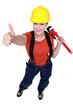 Woman holding wrench and giving thumbs-up