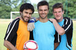 Foto: three football players in casual clothes posing for the photo three football players in casual clothes posing for the photo