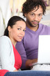Couple using a laptop at home