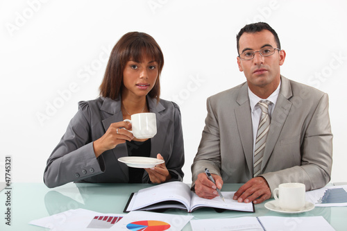 Photo: business people examining a project with a coffee business people examining a project with a coffee