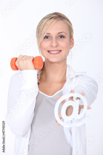 Photo: Young woman with a dumbbell and an internet @ sign Young woman with a dumbbell and an internet @ sign