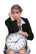 blonde with clock looking bored