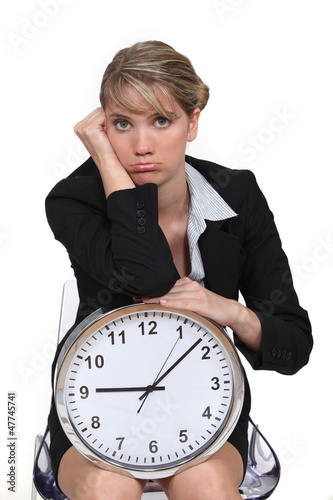 Photo: blonde with clock looking bored blonde with clock looking bored