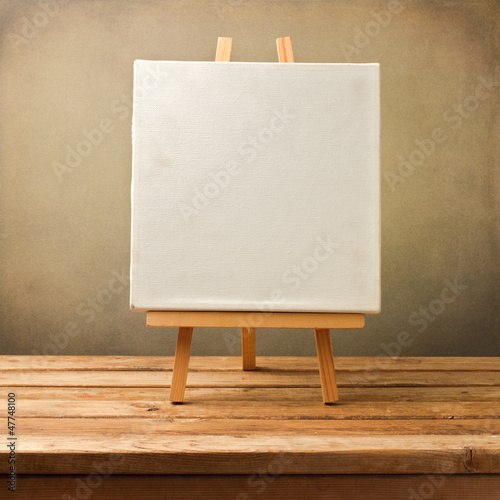 Photo: Background with blank canvas on wooden table Background with blank canvas on wooden table