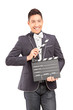 A smiling man holding a movie clap