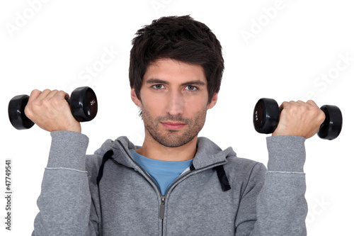 Photo: A man lifting weights. A man lifting weights.