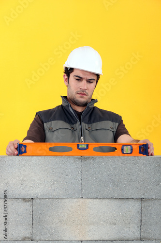 Photo: Bricklayer with a spirit level Bricklayer with a spirit level