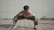 Man practices yoga on the roof. Squats 2.