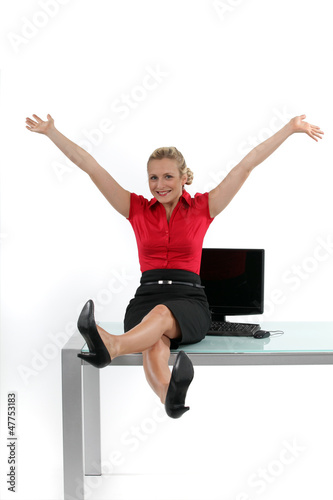 Photo: Relaxed woman sitting on her desk Relaxed woman sitting on her desk