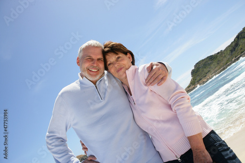 Photo: Old couple at the beach enjoying their retirement Old couple at the beach enjoying their retirement