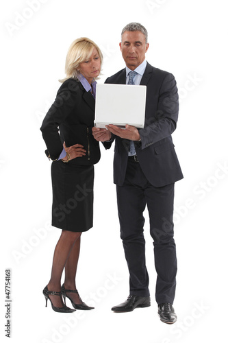 Photo: Senior business couple stood with laptop Senior business couple stood with laptop