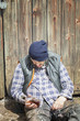Homeless leaning against barn door