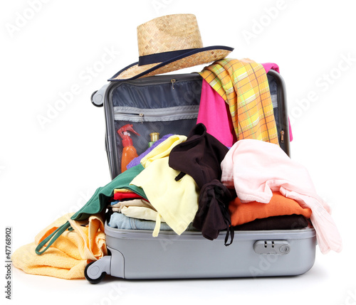 Photo: Open silver suitcase with clothing isolated on white Open silver suitcase with clothing isolated on white