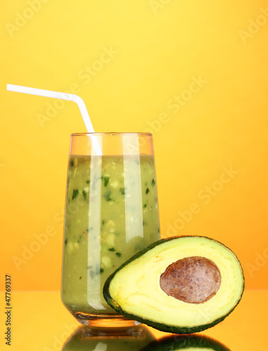 Photo: Useful fresh avocado and half avocado on orange background Useful fresh avocado and half avocado on orange background