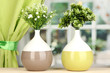 Decorative flowers in vases on windowsill