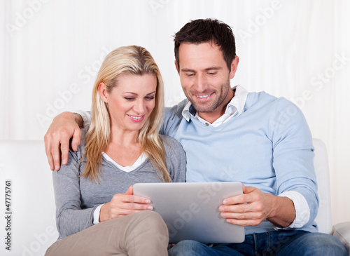 Photo: Couple looking at a tablet together Couple looking at a tablet together
