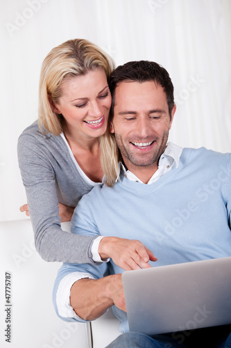 Photo: Couple laughing over information on a tablet Couple laughing over information on a tablet