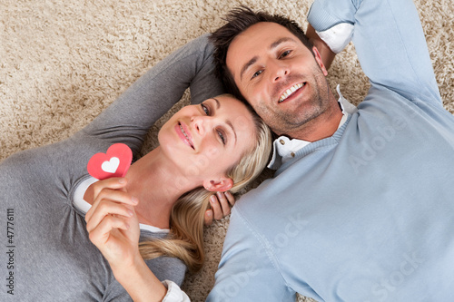 Photo: Man and woman lying head to head on the carpet Man and woman lying head to head on the carpet