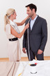 Seamstress measuring a man for a suit